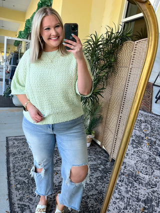 Lime green short-sleeve knit sweater top with textured fabric and crew neckline.
