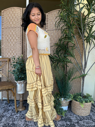 White crochet top with orange cap sleeves and yellow floral embroidery detail.
