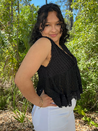 Black textured halter top with lace trim and draped fabric detail.
