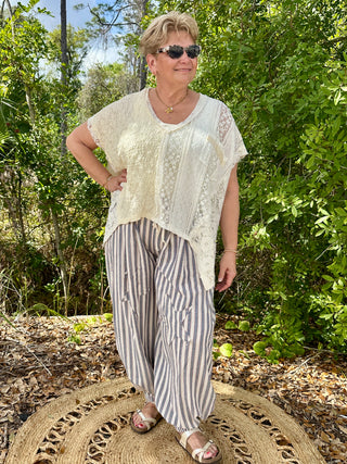 Cream lace short-sleeve top with blue and white striped jogger pants.
