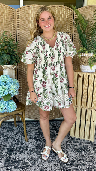 Cream boho floral dress with burgundy and green leaf pattern, short sleeves, lace trim hem.
