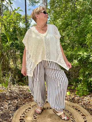 Cream lace short-sleeve top with blue and white striped jogger pants.
