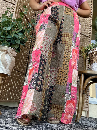 Pink and gray patchwork boho pants with mixed floral and geometric prints, contrast stitching detail, relaxed fit.

