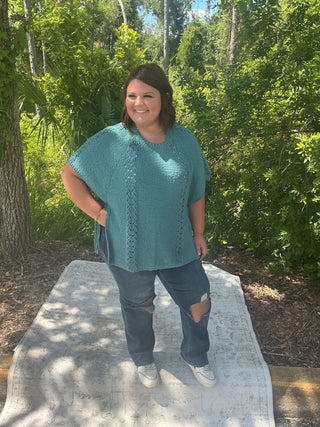 Light gray short sleeve poncho sweater with crochet accents and side ties