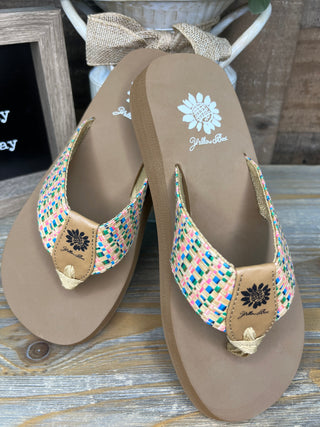 Beige flip flop sandals with colorful woven multicolor straps and daisy embroidery detail.
