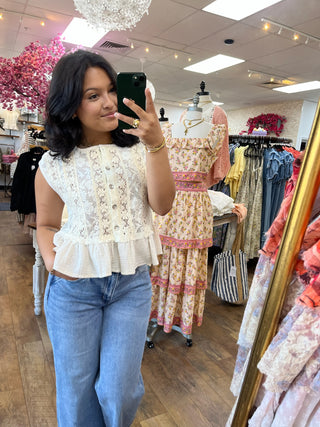 Cream lace cap-sleeve top with ruffle tier hem and peplum waist detail.
