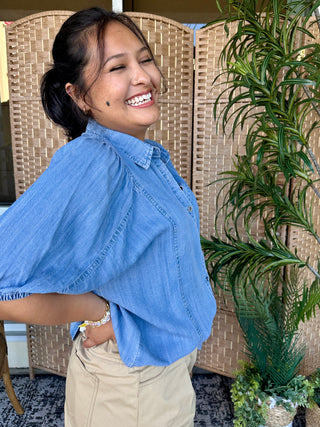 Light blue chambray button-up shirt with short sleeves and collar.
