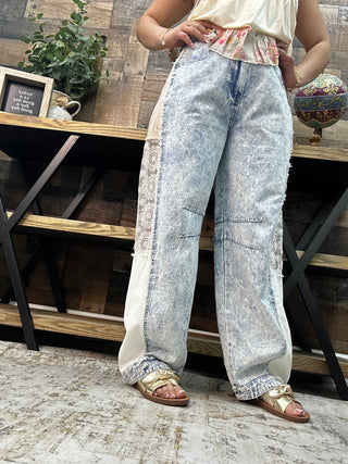 Light acid wash denim barrel leg jeans with cream lace side panels and stripe detail.

