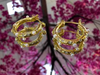 Gold layered hoop earrings with pearl and rhinestone accents, textured branch design.

