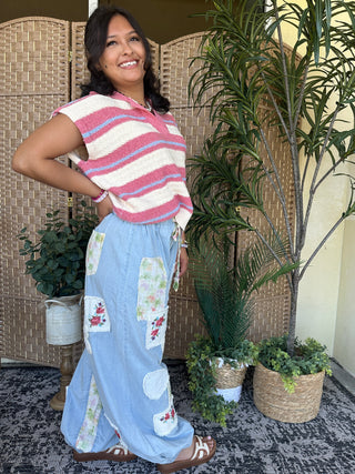 Dusty red and white striped sleeveless sweater top with wavy horizontal stripes.
