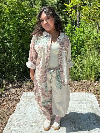 Ivory jogger pants with a colorful floral patchwork design and elastic waistband