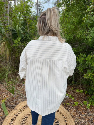 Ivory and black striped button-down top with oversized fit and rolled sleeves.
