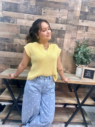 Yellow ribbed knit sweater vest with cap sleeves and split neckline.
