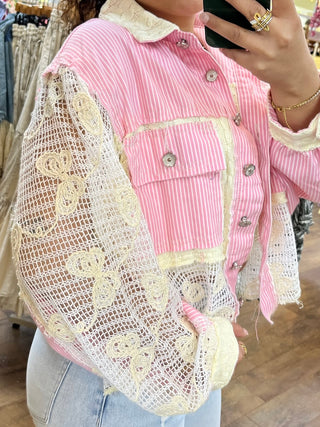 Pink and white striped shacket with cream lace sleeves and collar, featuring metal button details.
