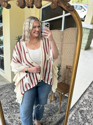Cream and red striped waffle knit cardigan with ruffled edges over white tank top.
