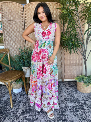 Sleeveless floral maxi dress in pink and multicolor blooms with V-neckline and gathered waist detail.
