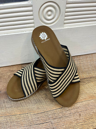 Black and tan striped criss-cross slide sandal with woven textile upper and tan footbed.
