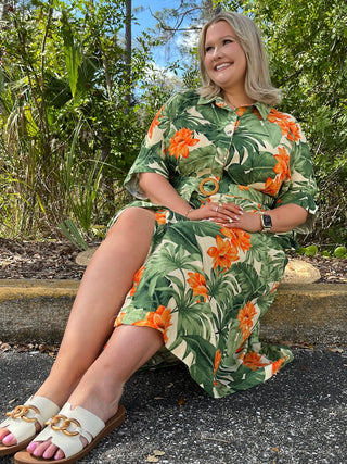 Tropical floral midi dress with orange flowers and green leaves, short sleeves, belted waist in cream and green colorway.
