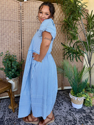 Blue and white vertical striped midi dress with puff sleeves and cutout detail at side.
