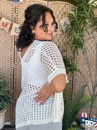 White dolman top with eyelet cutout pattern and short sleeves.
