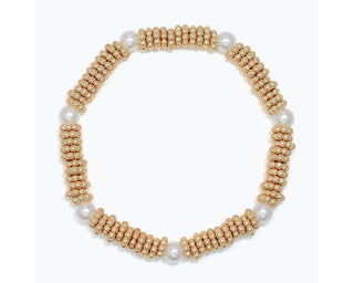 Gold disc beads with pearl spacer beads stretch bracelet on white background.
