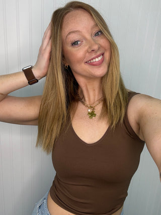 Brown buttery soft reversible seamless tank top on woman with arms raised.
