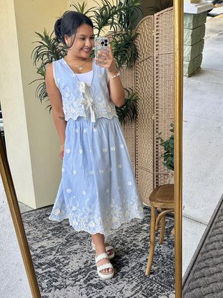 Light blue striped skirt set with white embroidered floral details and lace vest top.
