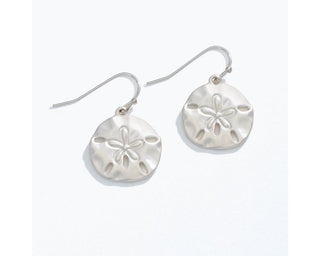 Silver matte sand dollar drop earrings with hook closures.
