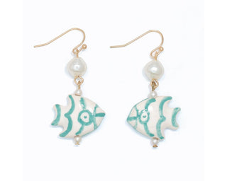 Gold fish-shaped earrings with turquoise wave patterns, pearl beads, and gold hooks on white background.
