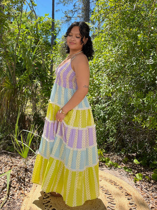 Tiered maxi dress in purple, blue, and yellow with geometric leaf print and color-block design.
