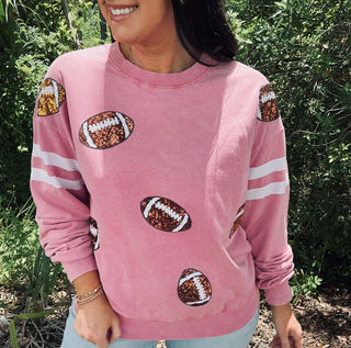 Bright hot pink top with dazzling sequin football patches, perfect for game day fashion and team spirit.