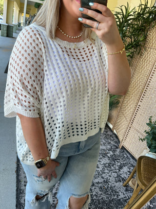 White knit dolman top with open eyelet pattern and short sleeves.
