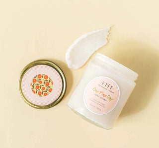 FHF One Fine Day Face Polish in a clear jar with a creamy texture, surrounded by fresh lemon and lime slices.