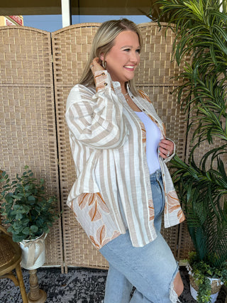 Taupe and white striped button-down top with orange floral trim detail on sleeves and hem.
