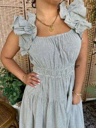 Light blue and white striped seersucker midi dress with dramatic ruffled off-shoulder sleeves.

