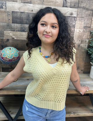 Butter yellow open knit sweater vest with v-neckline and short sleeves.
