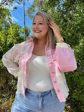 Pink striped button-up shacket with cream lace sleeves and trim, worn with white tank top.
