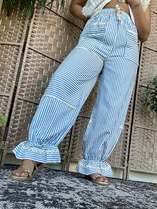 Blue and white striped jogger pants with ruffled cuffs and drawstring waist.
