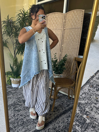 Oversized chambray tank top in light blue with eyelet cutout details and frayed edges.
