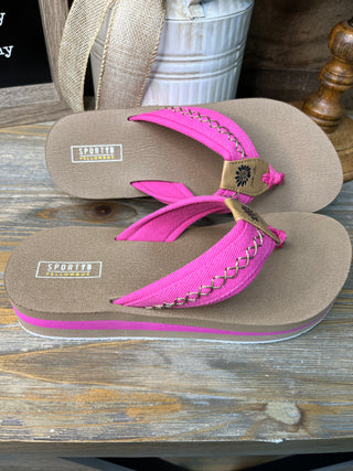 Tan flip-flops with hot pink fabric straps and decorative chain detail on footbed.
