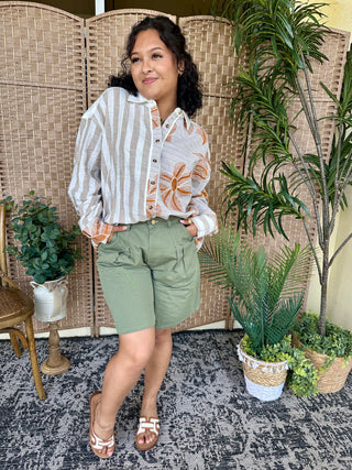 White and gray striped button-down shirt with orange floral print panels and pockets.
