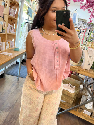 Rose pink waffle-knit sleeveless tank top with button placket detail.
