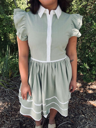 Chic matcha green linen dress with white trim, perfect for summer; features a relaxed fit and elegant short sleeves.