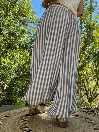 Gray and white striped jogger pants with tapered cuffs and relaxed fit silhouette.
