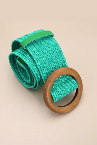 Teal green rattan belt with a round wooden buckle, showcasing a stylish accessory for casual and formal outfits.