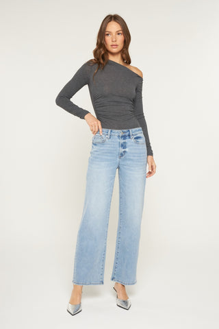 Charcoal gray off-shoulder long-sleeve top with light wash loose fit jeans.
