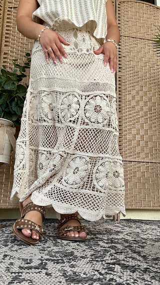 Cream crochet midi skirt with mixed lace patterns and openwork details, worn with sleeveless knit top.
