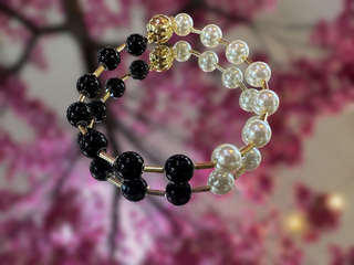 Black and white pearl magnetic bracelet with alternating round beads and metallic spacers.
