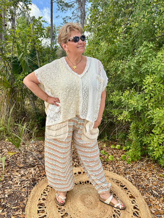 Cream textured top with lace panel over peach and aqua striped cropped pants.
