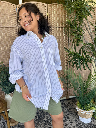Light blue pinstripe button-up shirt with relaxed fit and rolled sleeves.
